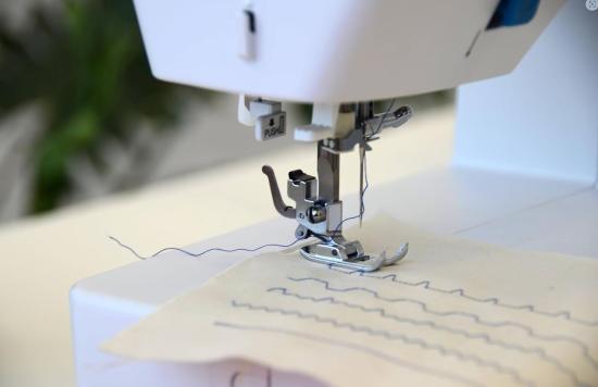 Nähmaschine beim Nähen mit Stoff und Faden