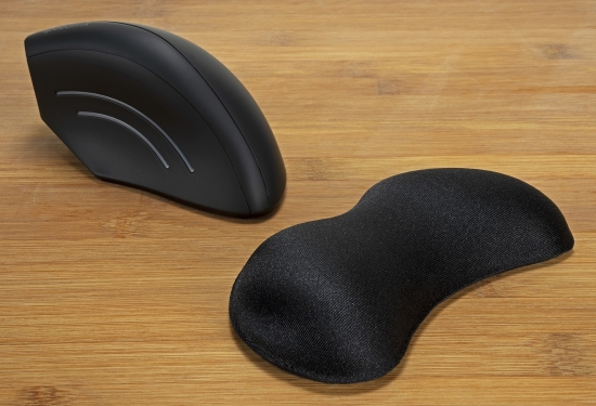 Eine ergonomische Maus und eine dazugehörige Handgelenkstütze auf einem Holztisch
