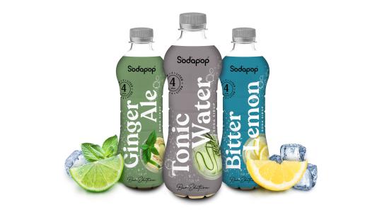 Drei Flaschen Sodapop Getränke: Ginger Ale, Tonic Water und Bitter Lemon mit Limetten und Zitronen.